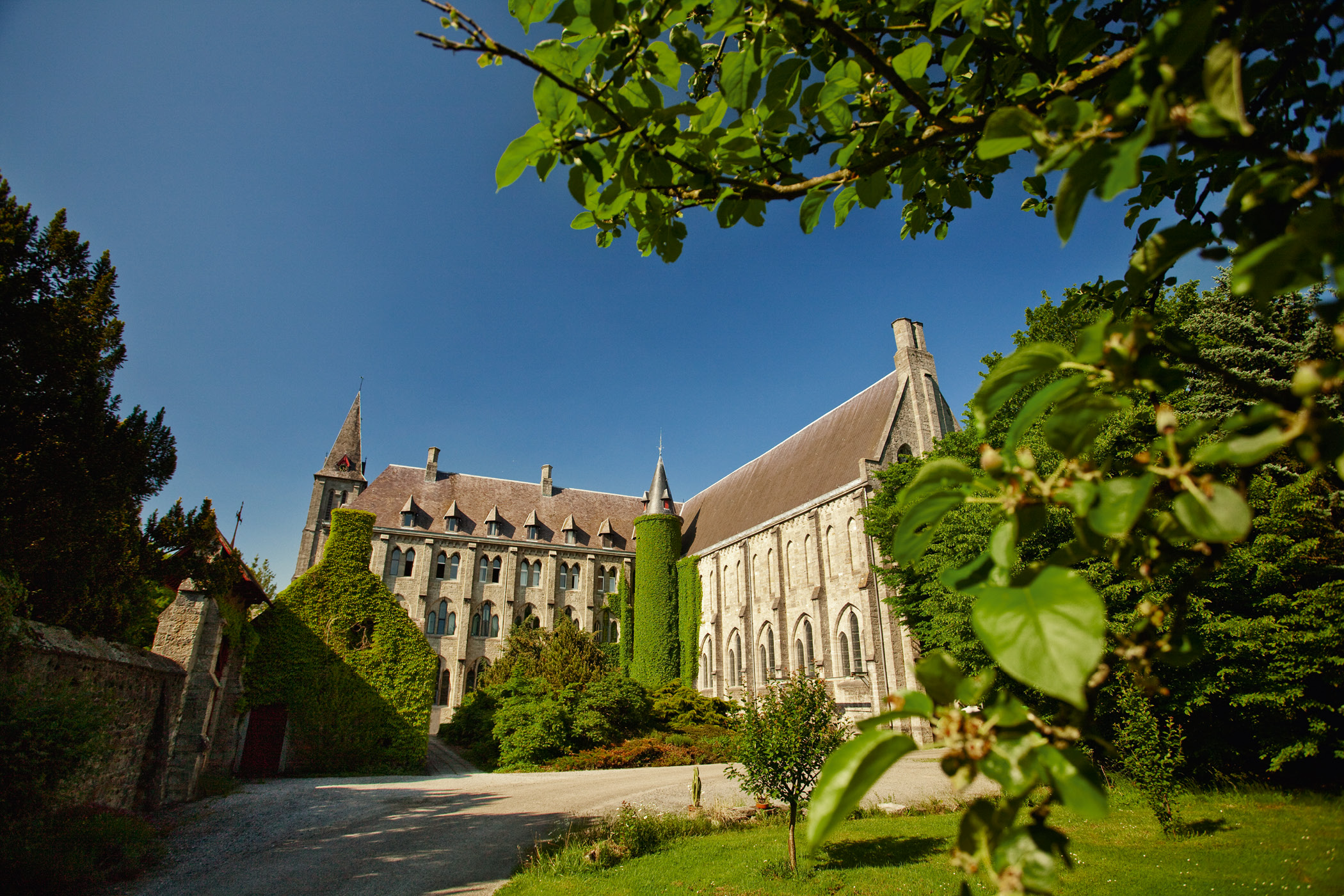 Bâtiments en pierre de l’abbaye de Maredsous encadrés de verdure
