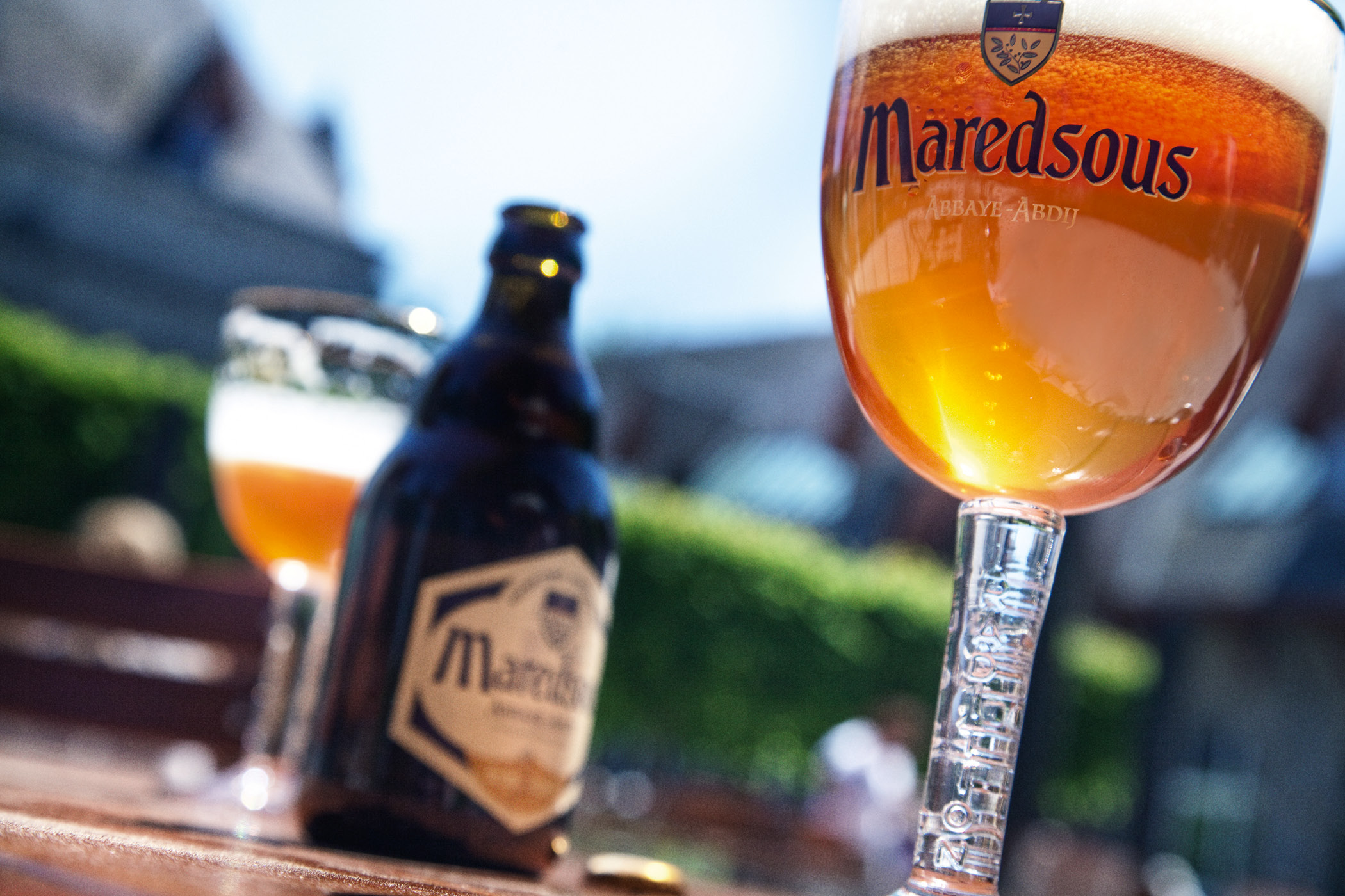 Verre de bière de Maredsous, avec l’abbaye en arrière-plan